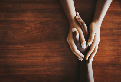 Cropped hand of woman gesturing on wooden table