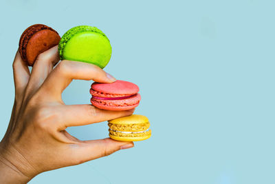 Hand holds colorful french macarons