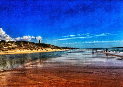 Scenic view of beach against blue sky