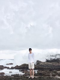 Portrait of young man standing against sky