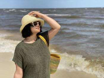 Woman wearing hat while standing on beach
