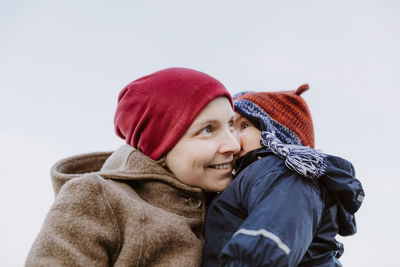 Close-up smiling woman with daughter during winter