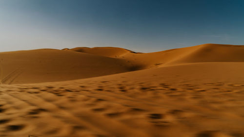 Sand dunes in desert against sky