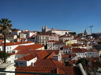 Aerial view of townscape against blue sky