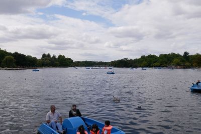 People enjoying in river against sky