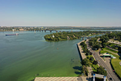 High angle view of city by sea against clear sky