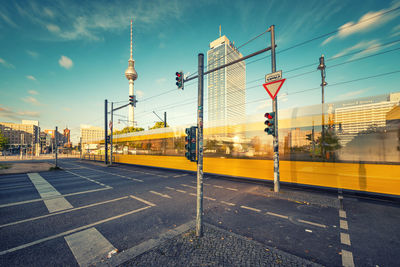 View of city street against cloudy sky