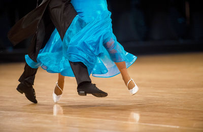 Low section of people dancing on hardwood floor