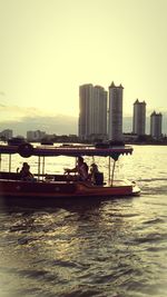 Boats in river with buildings in background