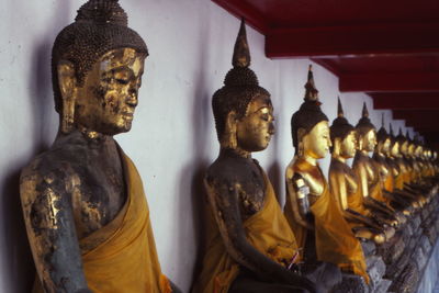 Row of metallic buddha sculptures at temple