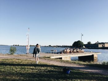 View of people in water against clear sky