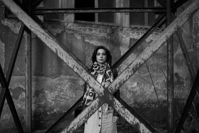 Portrait of beautiful young woman standing against building