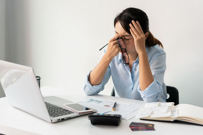 Young woman using laptop at desk in office