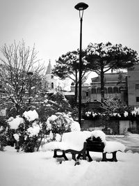 People on snow covered field by building