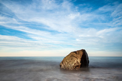 Rocks on sea shore against sky