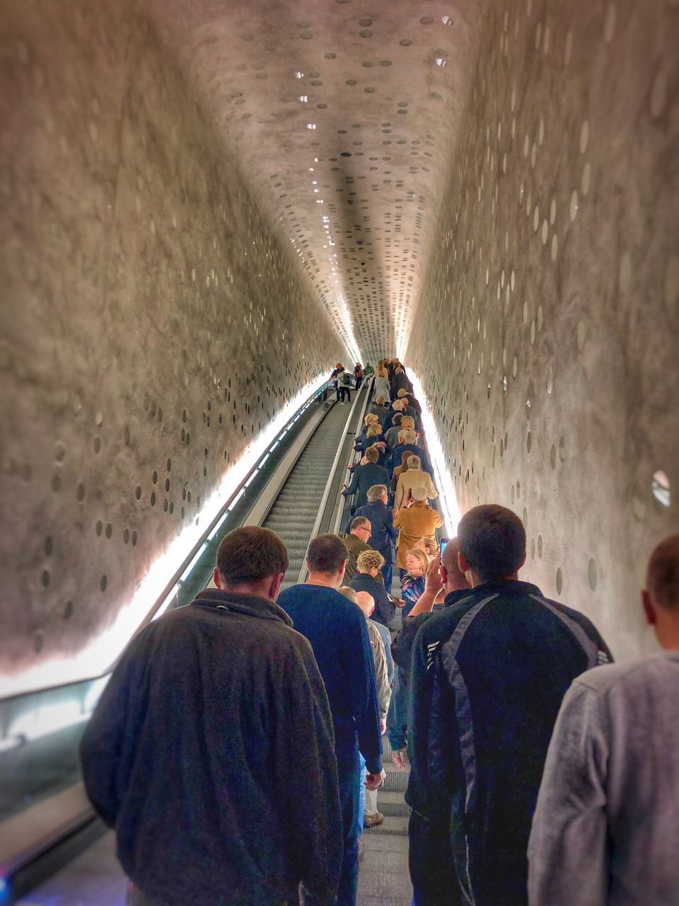 REAR VIEW OF PEOPLE WALKING ON SUBWAY PLATFORM