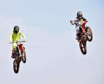 Man jumping wheel against clear sky