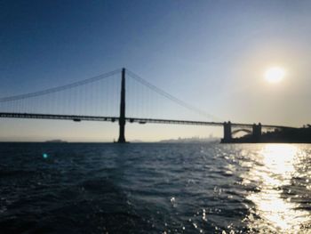 Bridge over sea against sky during sunset