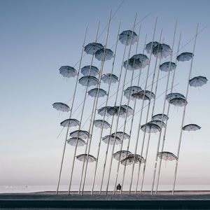 Low angle view of poles in sea against clear sky