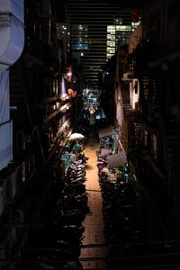 Narrow street amidst buildings in city at night