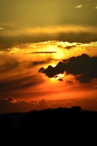 Scenic view of mountains against cloudy sky at sunset