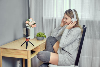 Portrait of young woman sitting on table