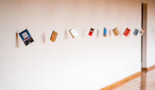 Miniature books hanging against wall