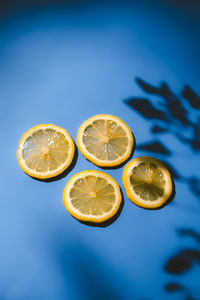 Low angle view of lemon slice against blue papper