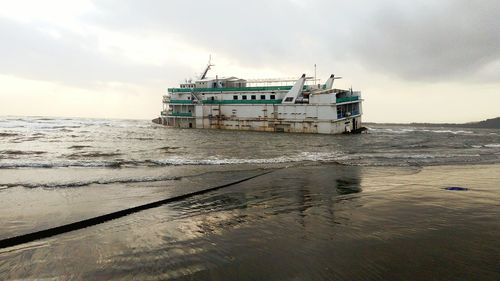 Damaged ship on sea against sky