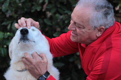 Close-up of senior man petting dog at park