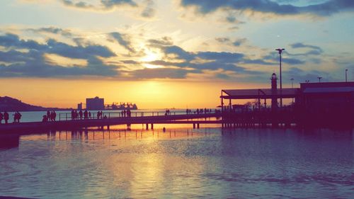 Pier in sea at sunset