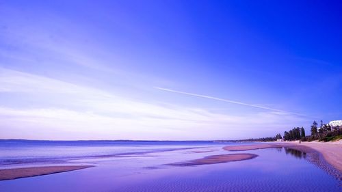 Scenic view of beach against blue sky