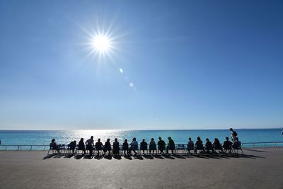 People on beach against clear sky