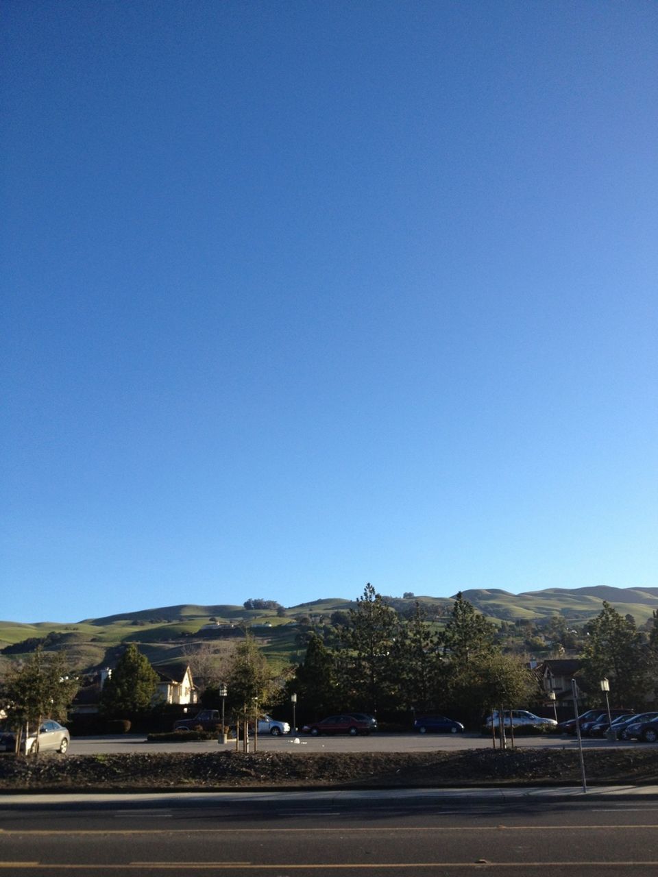 clear sky, copy space, blue, road, mountain, transportation, landscape, tranquility, tranquil scene, tree, nature, scenics, street, beauty in nature, day, outdoors, mountain range, built structure, no people, country road