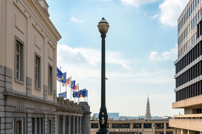 Street light amidst government building in city against sky