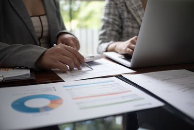 Midsection of businessman working on table