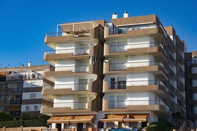 Low angle view of buildings against clear blue sky