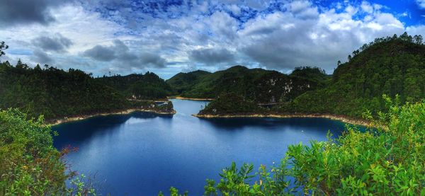 Scenic view of lake by trees against sky