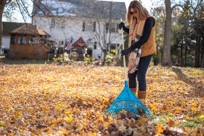 Full length of woman standing in park during autumn