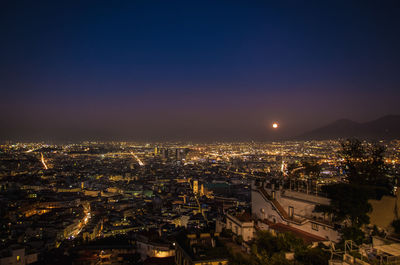 High angle view of illuminated city against sky at night
