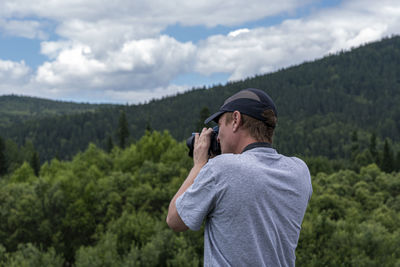 Man standing on mountain against sky