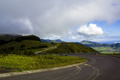 Road leading towards mountains against sky