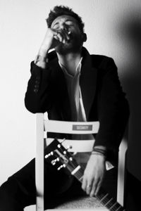 Young man sitting on wall at home