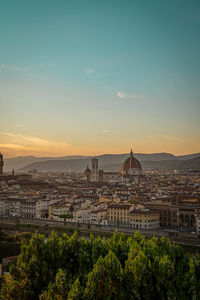 View of buildings in city at sunset