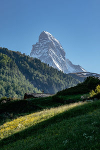 Scenic view of snowcapped mountains against clear blue sky