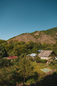 Scenic view of landscape and mountains against clear blue sky
