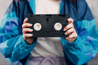 Midsection of woman holding cassette