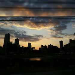 View of cityscape against cloudy sky