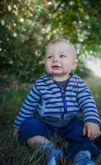 Portrait of cute boy sitting outdoors