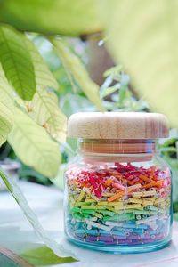 Close-up of notes in glass jar on table